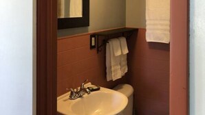 A bathroom with a sink, mirror, and toilet.