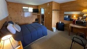 A small, cozy room with a bed, a desk, a chair, a microwave, a lamp, and a television. - Lyons in Onaway - 1 Full Bed - Room 5 - Sleeps 2 (Onaway)