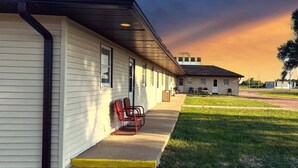 Un motel con un área de estar al aire libre techada y un césped.