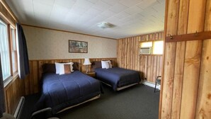 A room with two beds, a desk, and a chair.