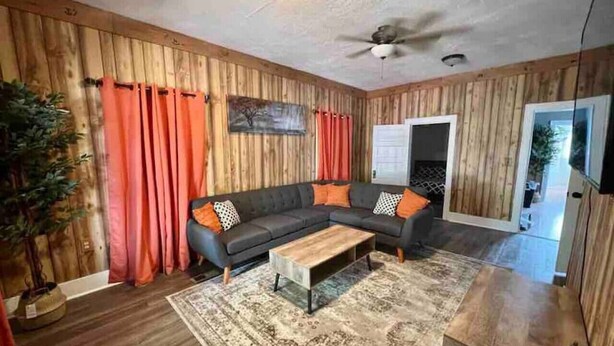 A living room with a sectional sofa, a coffee table, and a patterned rug. - The Western Roost | A Vensérra Retreat Near Hot Springs State Park (Thermopolis)