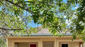 A single-story house with a front porch, a door, and a window. - The Western Roost | A Vensérra Retreat Near Hot Springs State Park (Thermopolis)