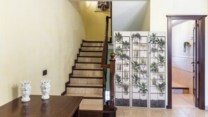 A staircase with a wooden handrail, a wall-mounted air conditioning unit, and a decorative plant wall. - Casa Amica - Three Bedroom House, Sleeps 6 (Avola)