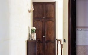 A wooden double door with a small table and vase in front.
