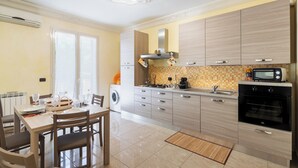 A modern kitchen with a dining area, built-in appliances, and a large window. - Casa Amica - Three Bedroom House, Sleeps 6 (Avola)