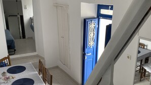 Ein Essbereich mit Tisch, Stühlen und einer blauen Tür im Hintergrund.