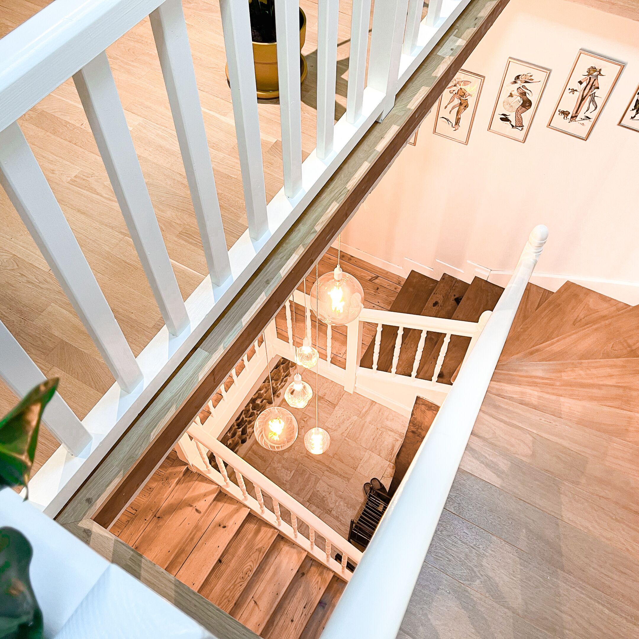 Una escalera de madera con barandillas blancas que baja a un nivel inferior.