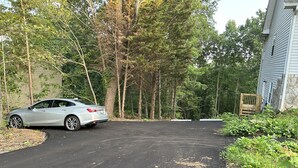 A car parked in a driveway with a stone house and a wooden gate in the background. - The Bear Den - Jasper Georgia (Jasper)