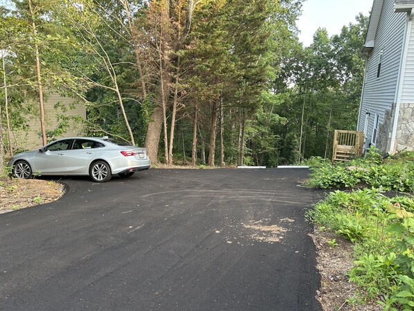 A car parked in a driveway with a stone house and a wooden gate in the background. - The Bear Den - Jasper Georgia (Jasper)