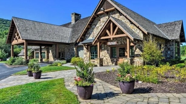 A stone building with a gabled roof and a covered porch.