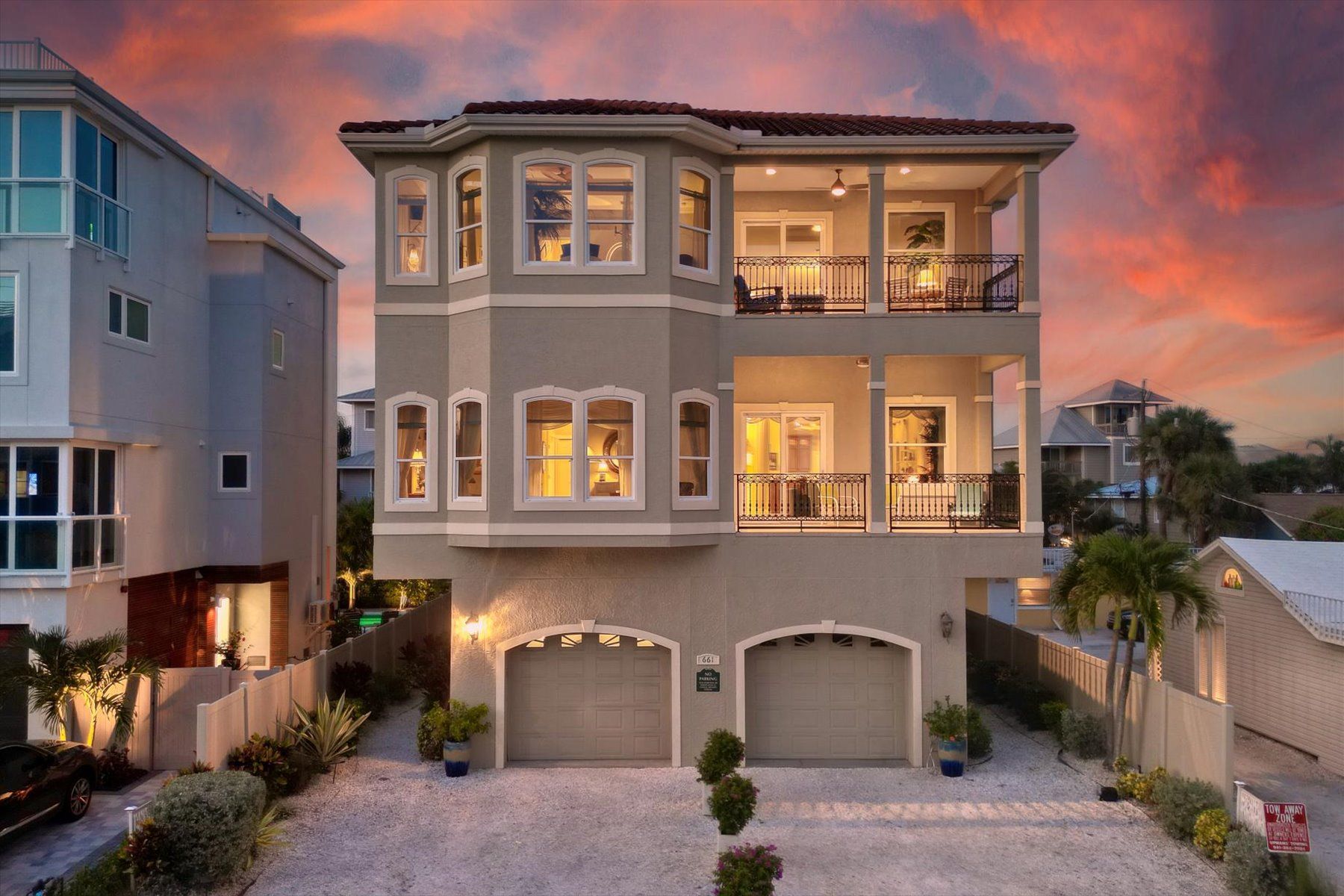 A two-story house with a garage, a balcony, and a driveway.