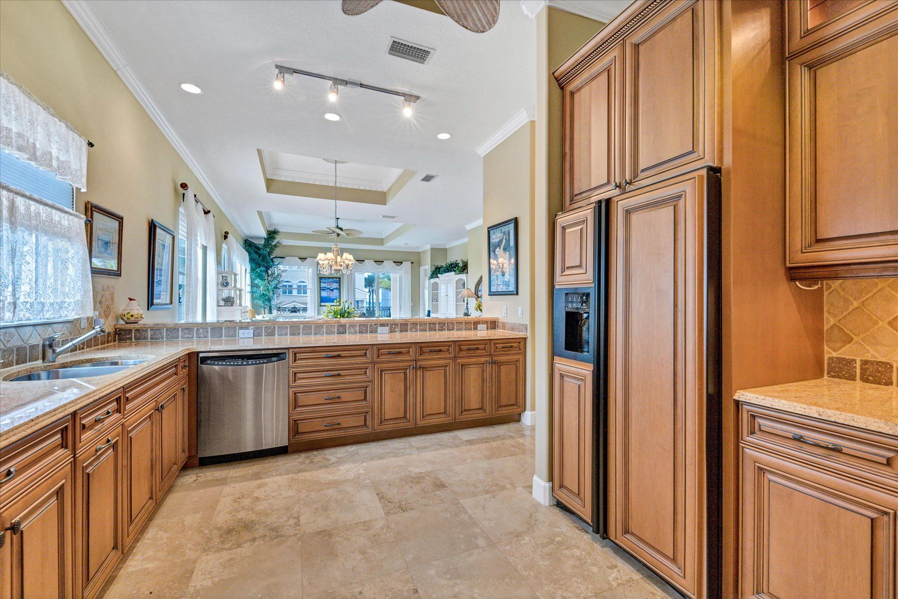A spacious kitchen with wooden cabinets, a dishwasher, and a large island.