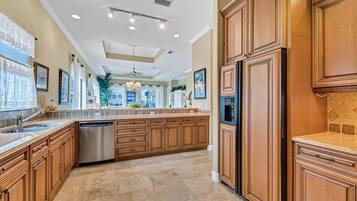 A spacious kitchen with wooden cabinets, a dishwasher, and a large island.
