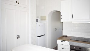 A modern kitchen with white cabinetry, a built-in oven, and a microwave.