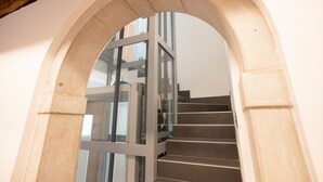 Un escalier avec une rampe en verre, menant à un étage supérieur.