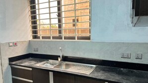 A kitchen with a window, a sink, and cabinets. - Racapa Apartments (Santeo)