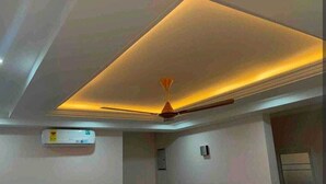 A room with a recessed ceiling, a ceiling fan, and a wall-mounted air conditioning unit. - Racapa Apartments (Santeo)