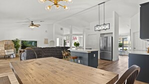 A spacious kitchen with a central island, modern appliances, and a dining area with a wooden table and chairs. - Luxury Corner Home, Arcade, Heated Pool & Spa. No extra fees. Pet Friendly. (Davenport)