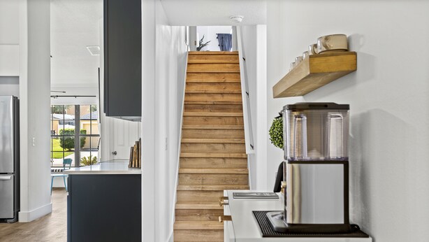 A modern kitchen with a wooden staircase leading to a dining area. - Luxury Corner Home, Arcade, Heated Pool & Spa. No extra fees. Pet Friendly. (Davenport)
