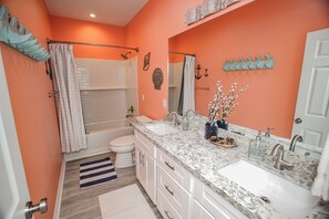Ein Badezimmer mit zwei Waschbecken, einer Badewanne und einer Toilette.