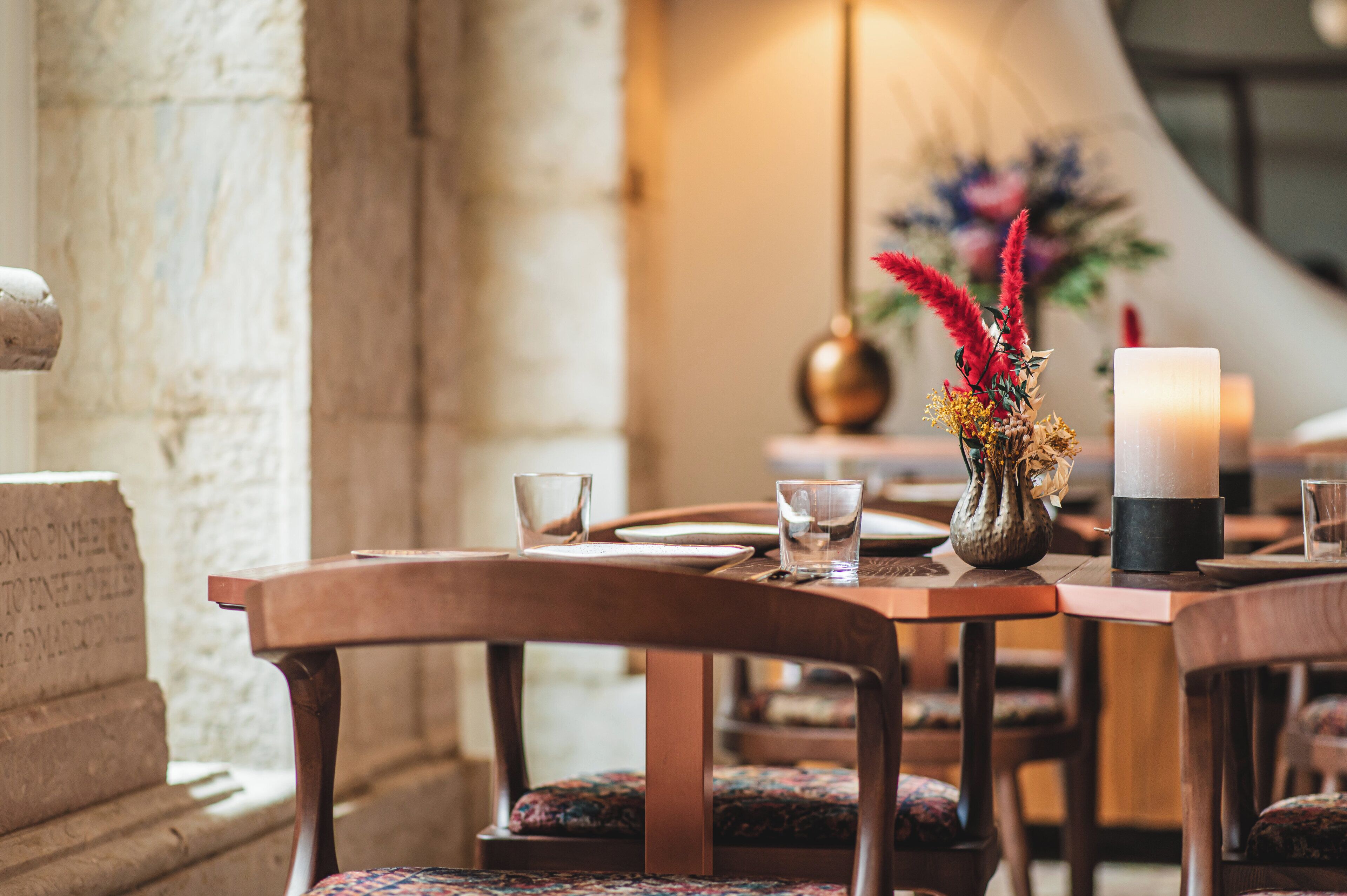 A dining table set with plates, glasses, and a candle.