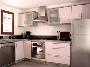 A modern kitchen with stainless steel appliances, a dishwasher, a stove, and a refrigerator.