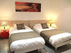 Une chambre d’hôtel avec deux lits, chacun étant équipé d’un oreiller et d’une lampe.