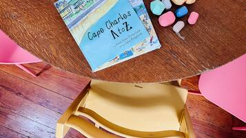 Ein Buch mit dem Titel 'Cape Charles Atz' auf einem Holztisch, neben dem farbige geometrische Formen liegen.