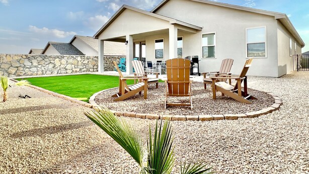 Een modern huis met een patio, compleet met tuinmeubilair en een verzorgd gazon.