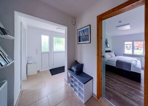 A modern hotel room with a bed, a desk, and a view of the outside. - Ferienhaus Direkt an der Wümme (Hellwege)