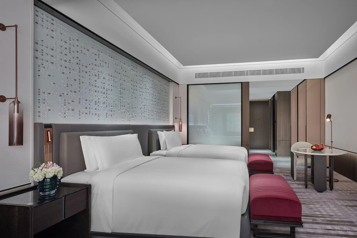 Una habitación de hotel moderna con una cama grande, un escritorio y una zona de estar.