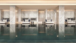 Un moderno espacio de spa con varias zonas de estar y una fuente central.