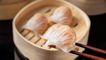 Gros plan d’une vapeur de raviolis cuits à la vapeur dans un panier en bambou.