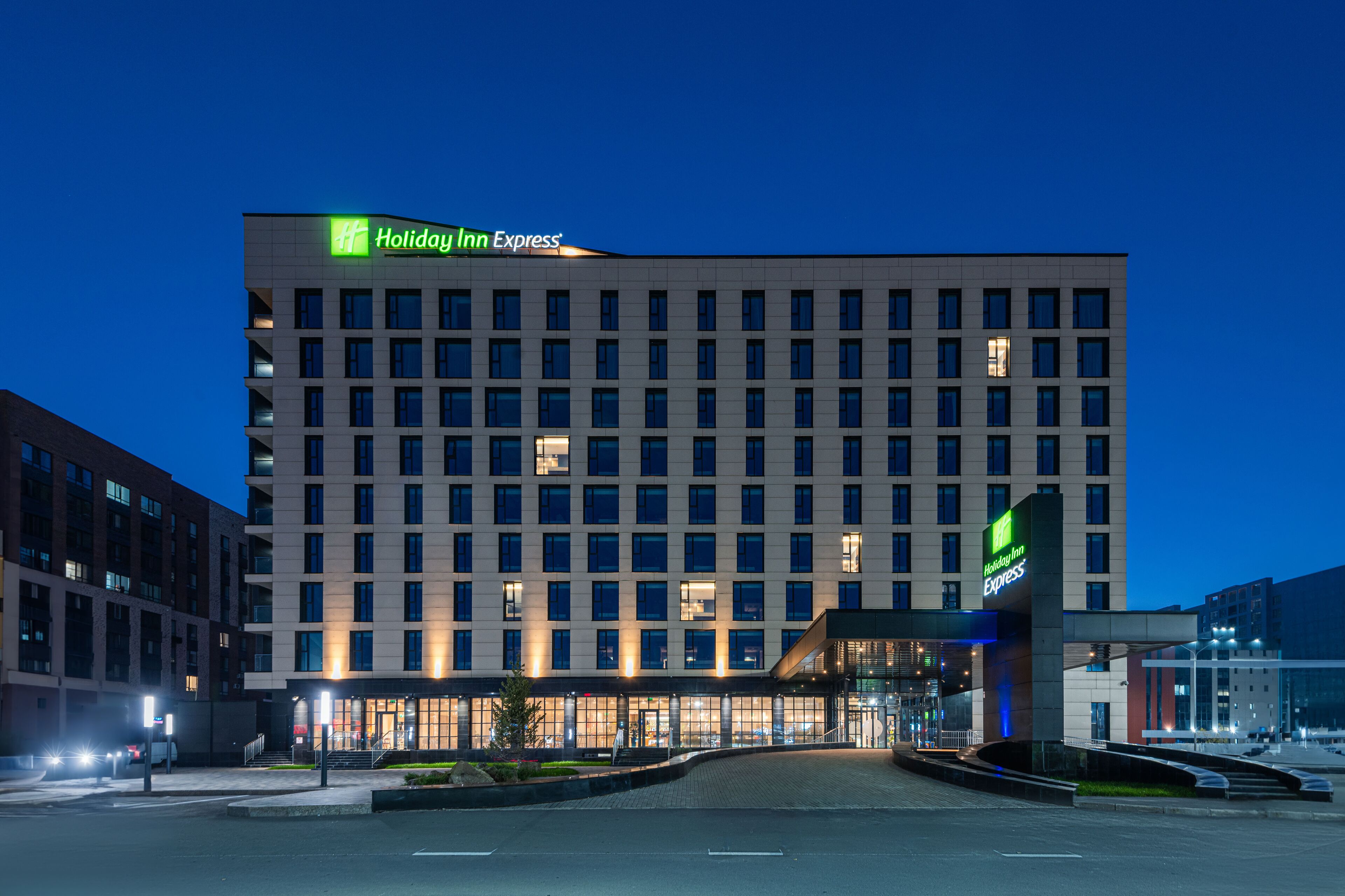 A Holiday Inn Express hotel with a modern facade, multiple floors, and a well-lit entrance area.