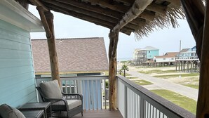 A wooden deck with wicker furniture and a railing overlooking a beach and ocean. - Short walk to the beach (Freeport)