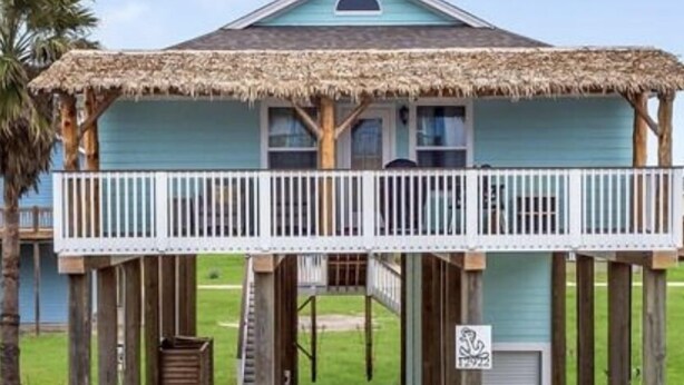 A beachfront house with a thatched roof, a balcony, and a covered walkway leading to the entrance. - Short walk to the beach (Freeport)