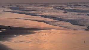 A sunset over the ocean with a beach in the foreground. - Short walk to the beach (Freeport)