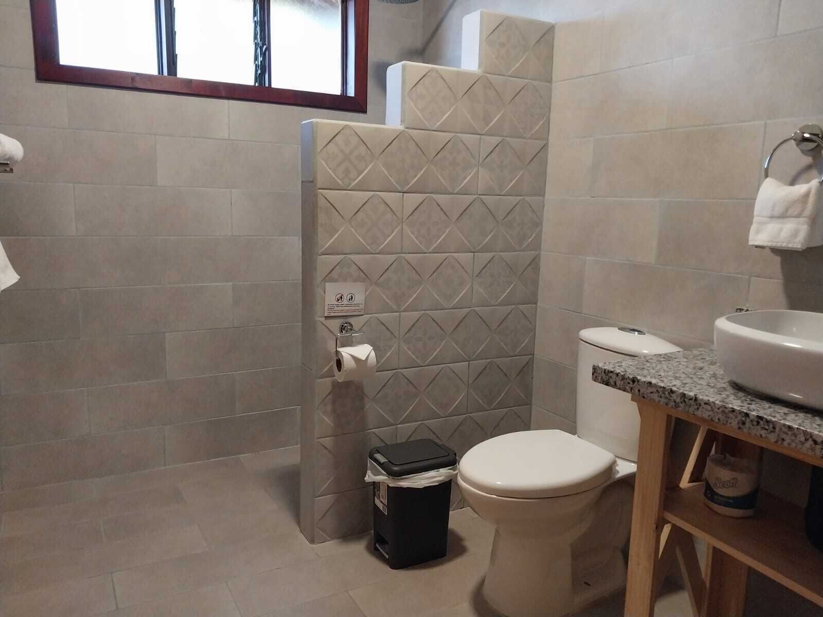 Ein Badezimmer mit Toilette, Waschbecken und Duschbereich.