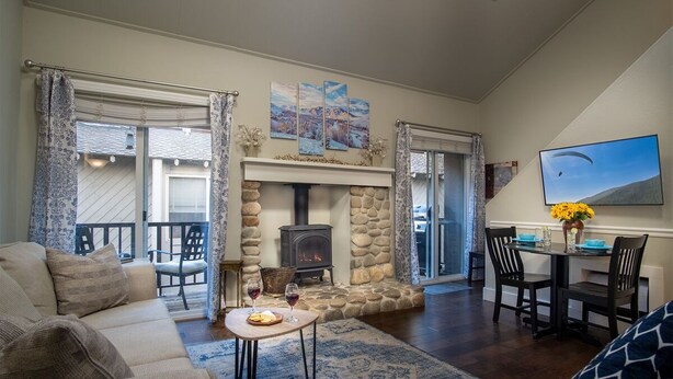 A cozy living room with a stone fireplace, a dining area with a table and chairs, and a sofa. - Sun Valley/Ketchum-Location, Hot tub, pet friendly, walk to ski and downtown (Ketchum)
