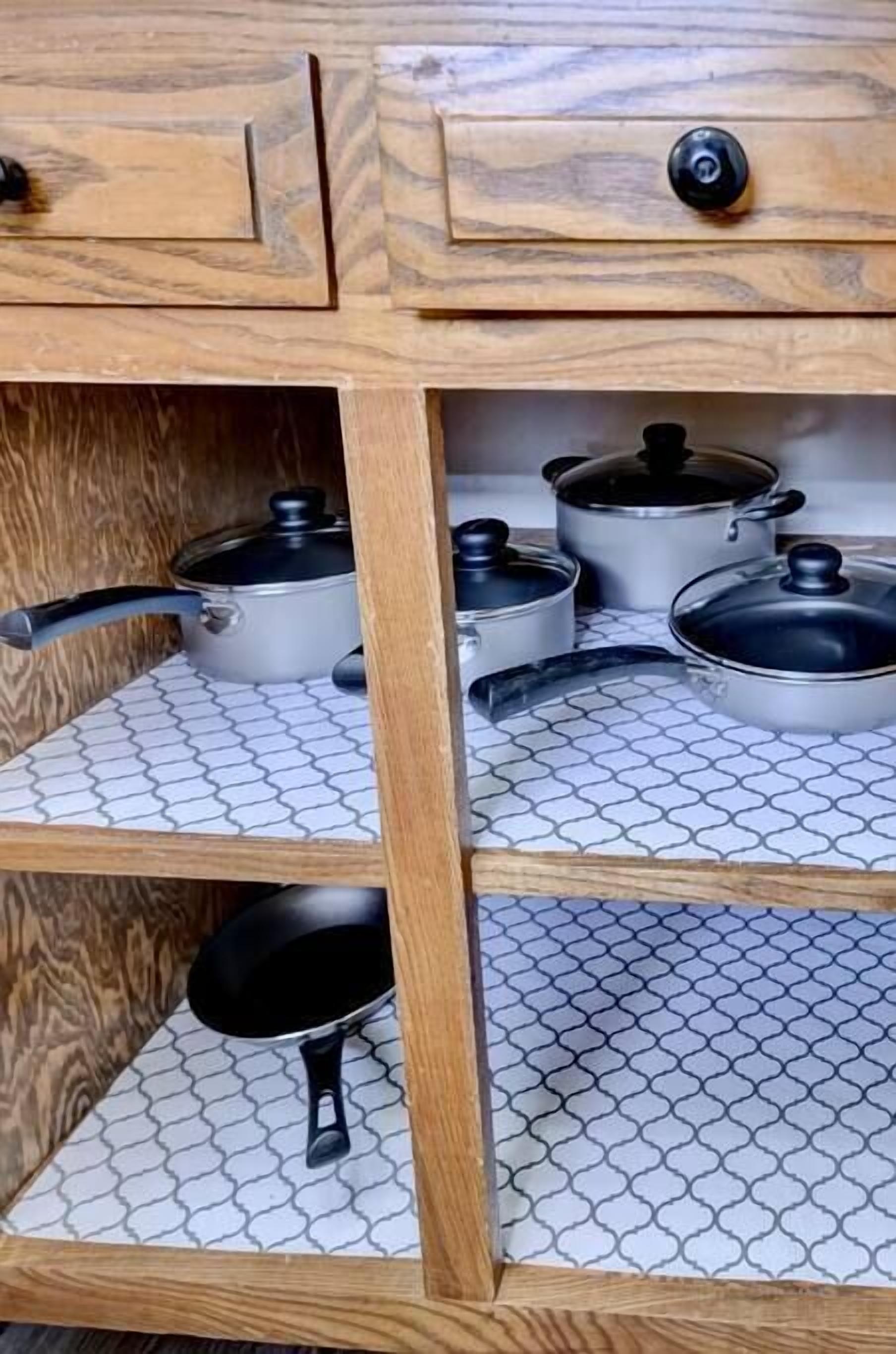 Eine Küchenschrank aus Holz mit drei Einlegeböden, auf jedem ein Topf und eine Pfanne.