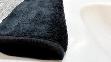 Ein schwarzes Handtuch auf einem weißen Waschbecken.