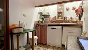 Una cocina compacta con lavavajillas, un fregadero y diferentes utensilios de cocina.