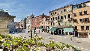 Una plaza histórica con arquitectura tradicional, que incluye un edificio destacado con un campanario.