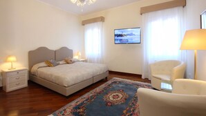 A hotel room with a bed, a TV, a chair, and a nightstand. - Apt. Splendid Venice (250m from St. Mark´s Square) (Venecia)