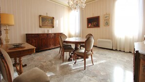 A dining room with a round table, chairs, a chandelier, a cabinet, and framed artwork on the wall. - Corner Canal View (300m from Rialto´s Bridge) (Venecia)