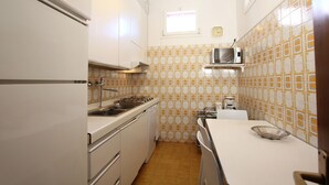 A compact kitchen with white cabinets, a microwave, and a sink. - Corner Canal View (300m from Rialto´s Bridge) (Venecia)