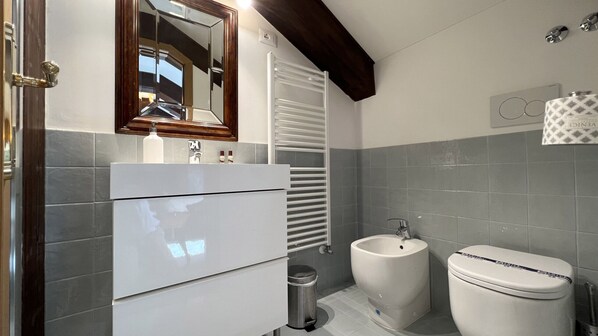 A bathroom with a white vanity, a sink, a bidet, and a toilet. - Zaffiro Grand Canal View (Venecia)