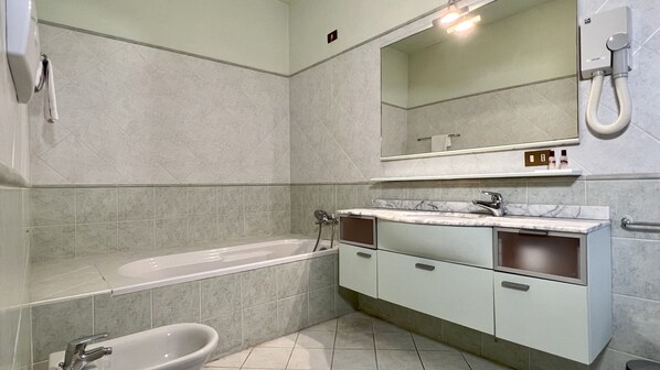 A modern bathroom with a bathtub, a sink, and a mirror.
