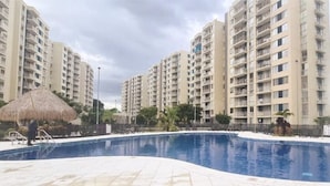 A swimming pool surrounded by high-rise residential buildings. - 207 AKUA RESORT® VACATION APARTMENT (Ricaurte)