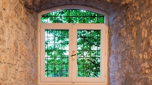 A stone-walled alcove with a bench and a window with a grid pattern. - Macchiaroli La Gioiosa Castle the magic of a medieval castle in Teggiano (Teggiano)